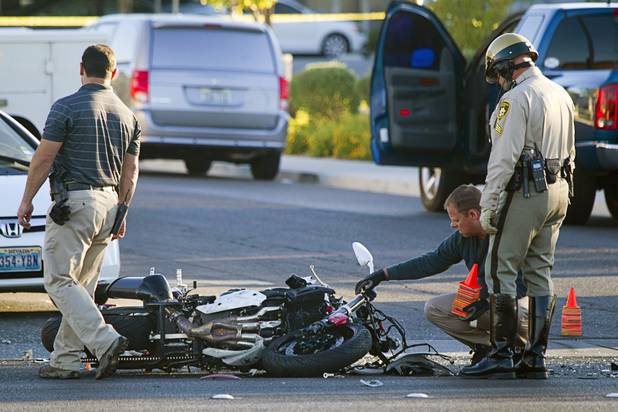 Metro Police investigators look over a motorcycle after a fatal accident on West Sahara Avenue near Buffalo Drive Wednesday, Oct. 16, 2013. 