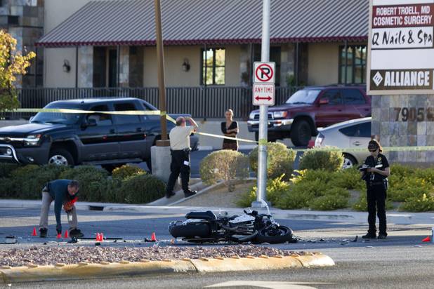 A Metro Police investigator picks up evidence cones after a fatal motorcycle accident on West Sahara Avenue near Buffalo Drive Wednesday, Oct. 16, 2013.