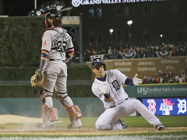 Detroit Tigers' Jose Iglesias reacts as he scores on a double by Torii Hunter in the second inning during Game 4 of the American League baseball championship series against the Boston Red Sox, Wednesday, Oct. 16, 2013, in Detroit. 