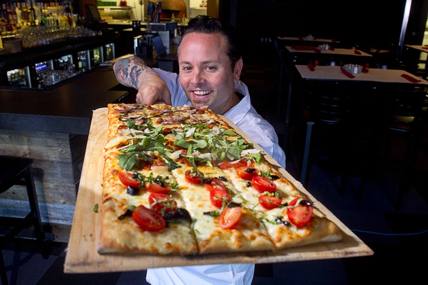 Tony Gemignani holds a Roman pizza at the new Pizza Rock restaurant at Third Street and Ogden Avenue in downtown Las Vegas Thursday, Oct. 17 2013.