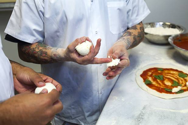Tony Gemignani, right, teaches Las Vegas Weekly food editor Brock Radke the correct way to rip the cheese as they make margherita pizzas at the new Pizza Rock restaurant at Third Street and Ogden Avenue in downtown Las Vegas Thursday, Oct. 17 2013.