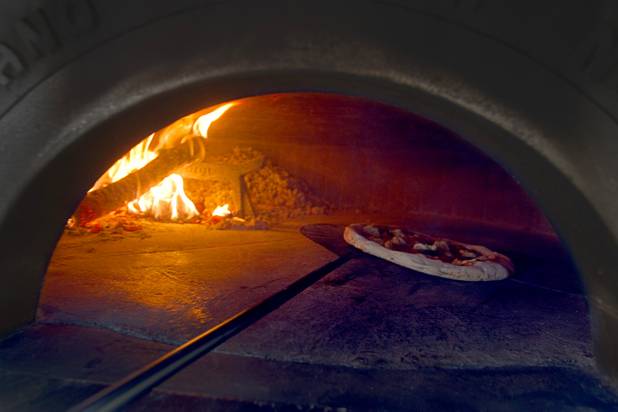 Tony Gemignani rotates a margherita pizza as it cooks in a wood-fired oven at the new Pizza Rock restaurant at Third Street and Ogden Avenue in downtown Las Vegas Thursday, Oct. 17 2013.