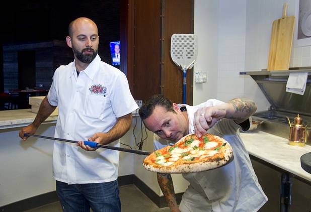 Tony Gemignani, right, inspects a margherita pizza made by Las Vegas Weekly food editor Brock Radke, left, at the new Pizza Rock restaurant at Third Street and Ogden Avenue in downtown Las Vegas Thursday, Oct. 17 2013.