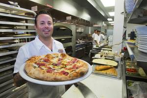 Tony Gemignani poses with a Cal Italia pizza at Pizza Rock restaurant at Third Street and Ogden Avenue in downtown Las Vegas Thursday, Oct. 17 2013.