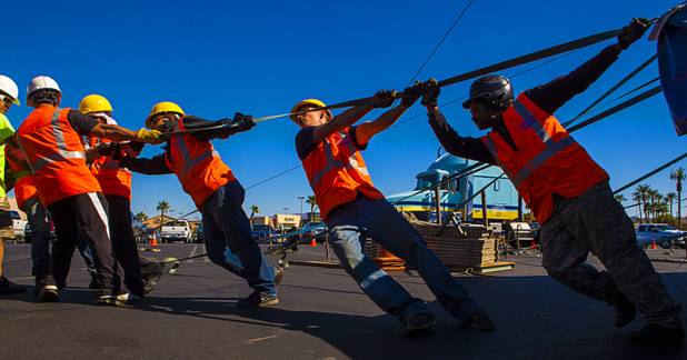 The Circus Vargas crew pulls hard to secure one of the many tent lines used to secure the big top in place atop the Galleria on Sunset parking lot Tuesday, Oct. 15, 2013.  L.E. Baskow.