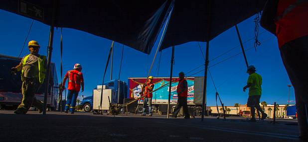 The Circus Vargas crew work to secure the many tent lines and poles used to secure the big top and smaller tents in place atop the Galleria on Sunset parking lot Tuesday, Oct. 15, 2013.  L.E. Baskow.