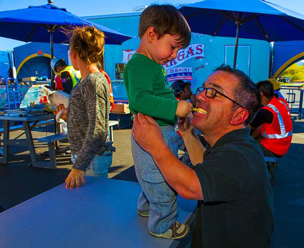 Allan Bachliyski, 2, shares a french fry with friend Arturo Figueroa as Circus Vargas members break for lunch Wednesday, Oct. 16, 2013.  L.E. Baskow.