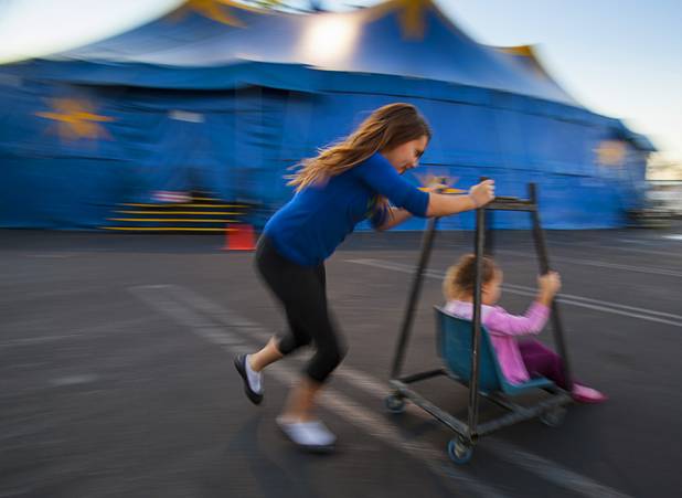 Circus Vargas kids Daniella Quiroga, 10, and sister Graciella, 4, spin around on a makeshift cart outside the big top as their parents ready for opening night Thursday Oct. 17, 2013.  L.E. Baskow.