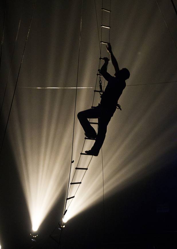 Circus Vargas crew member Gustavo Camura makes hiw way down a ladder after checking the trapese rigging for an opening night performance Thursday Oct. 17, 2013.  L.E. Baskow.