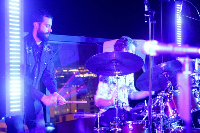 Sam Lemos jumps on the cow bell with drummer Pat Gray during their band, Moksha's, set at the "Rooftop Fall Ball 3" on the Binion's Gambling Hall & Hotel rooftop pool deck, Friday, Oct. 18, 2013.