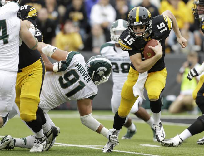 Iowa quarterback Jake Rudock (15) runs from Michigan State defensive tackle Tyler Hoover (91) during the first half of an NCAA college football game, Saturday, Oct. 5, 2013, in Iowa City, Iowa. 