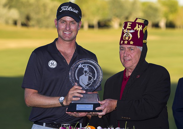 Webb Simpson of Charlotte, N.C. is presented with his trophy by Dale Stauss, CEO of the Shiners Hospitals for Children Open, after winning the Shriners Hospitals for Children Open at TPC Summerlin Sunday Oct. 20, 2013.