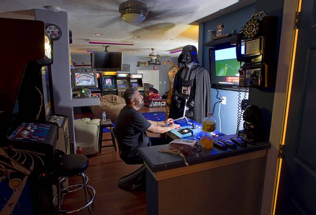 Craig Snelling plays video games at his home Tuesday, Oct. 22, 2013. Snelling built the custom console from scratch, he said. Snelling is a pinball machine repairman and owner of Billiards 'N More, a billiards and game room supply store.