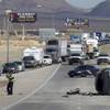 Nevada Highway Patrol troopers investigate at the scene of a rollover accident in the southbound lanes of I-15 near Lamb Blvd. Wednesday, Oct. 23, 2013. The vehicle was northbound but, possibly due to tire failure, the vehicle crossed the median and rolled. The driver was ejected and is reported in critical condition. A child in a car seat suffered non-life-threatening injuries, said NHP Trooper Jeremie Elliott.