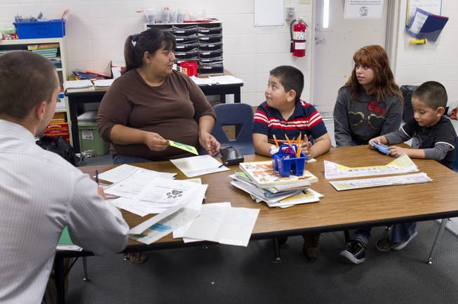 Irene Garcia, left, attends a parent-teacher conference for her son Miguel, center, at Lois Craig Elementary School in North Las Vegas Wednesday, Oct. 23, 2013. Her daughter Melynda, 15, helped with the interpretation. Another son Christopher, 3, is at right. About 80 percent of students at the school are Hispanic.