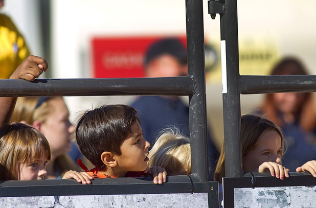 Children watch as Vance Rupp, 7, of Polk City, Iowa rides a sheep during a Mutton Bustin' competition at the Tyson Fan Zone & Marketplace at Mandalay Bay Thursday, Oct. 24, 2013. The event was part of the the 2013 Professional Bull Riders Built Ford Tough World Finals.