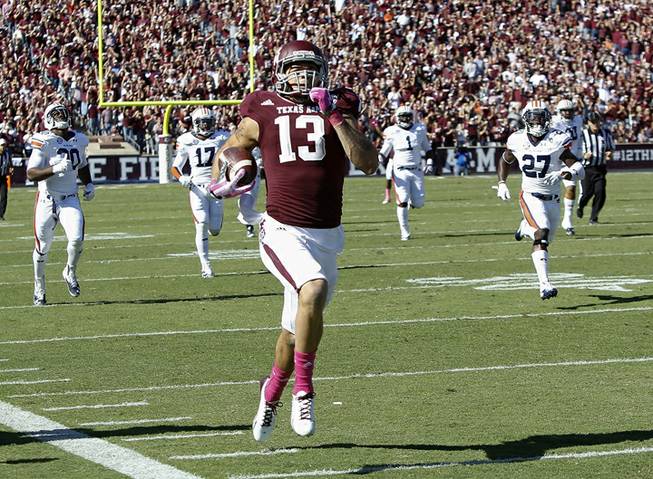 Texas A&M wide receiver Mike Evans (13) runs a 64-yard touchdown against Auburn in the first half during an NCAA college football game Saturday, Oct. 19, 2013, in College Station, Texas. 