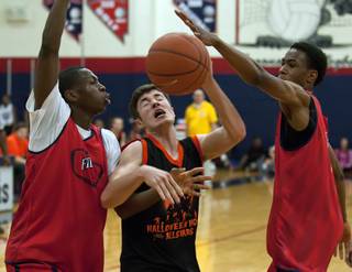 Findlay Prep players Renathan Ona Embo, left, and O'Shae Brissett converge to knock the ball away from a Halloween All-Stars player attempting to score a basket in the final seconds of a game at Coronado High School on Saturday night.