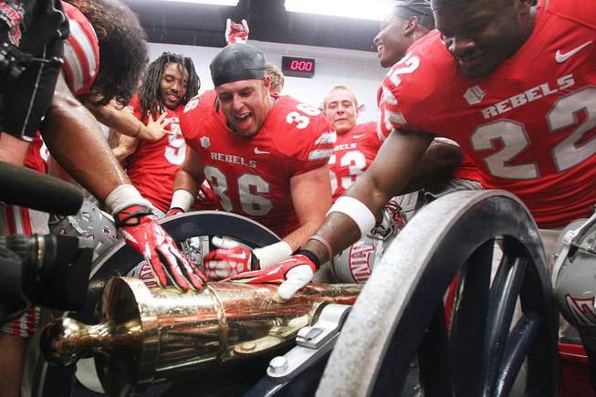 UNLV players surround the Fremont Cannon after defeating UNR 27-22 Saturday, Oct. 26, 2013 at Mackay Stadium in Reno.