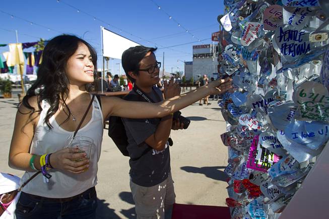 Cousins Ashley and Joey Bulosan of Las Vegas look over an art installation is shown during the Life is Beautiful Festival in downtown Las Vegas Sunday, Oct. 27, 2012. People create messages on heart-shaped, aluminum pieces that are padlocked onto the sculpture.