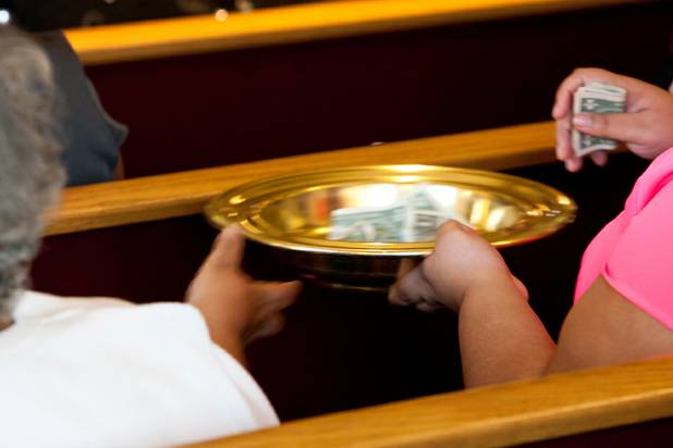 Church members give their tithes as they pass the offering plate during the morning service at the First African Methodist Episcopal Church in Las Vegas on Sunday, Oct. 27, 2013.