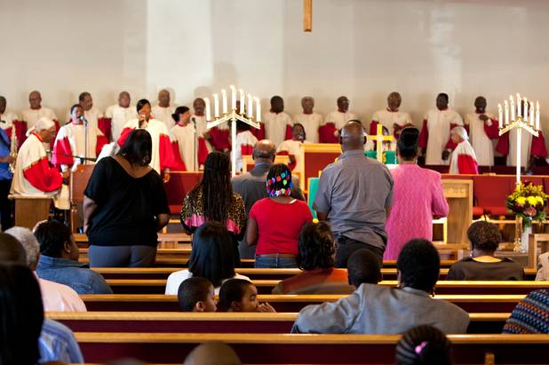 A family stands in praise as the choir sings during the morning service at the First African Methodist Episcopal Church in Las Vegas on Sunday, Oct. 27, 2013.