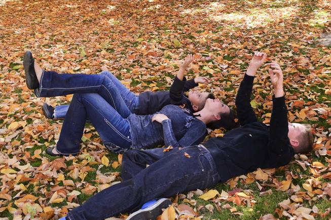 Chantelle Ewing and her sons, Shane, left, and Blake enjoy the falling leaves at the state capitol on Sunday, Oct. 27, 2013.