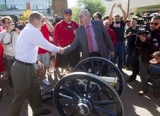 Head Football coach Bobby Hauck, left, is congratulated by UNLV President Neal Smatresk by the Fremont cannon before a painting ceremony on UNLV campus Monday, Oct. 28, 2013. The UNLV football team beat Reno Saturday 27-22 to break an eight-year losing streak in the rivalry game and gain possession of the Fremont cannon. 