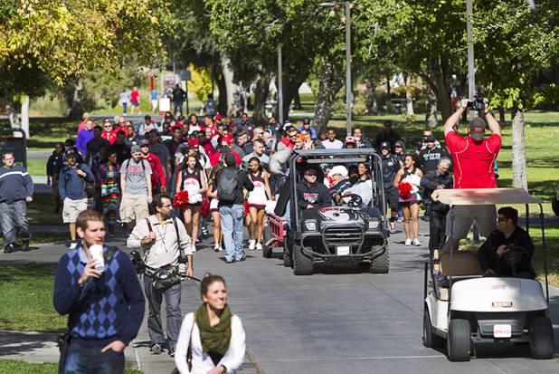 A procession accompanies the Fremont cannon as it arrives for a painting ceremony on UNLV campus Monday, Oct. 28, 2013. The UNLV football team beat Reno Saturday 27-22 to break an eight-year losing streak in the rivalry game and gain possession of the Fremont cannon.
