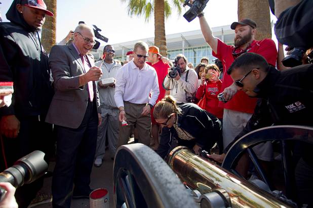 UNLV President Neal Smatresk, left, head football coach Bobby Hauck, center, and athletic director Tina Kunzer-Murphy paint the Fremont cannon during a ceremony on UNLV campus Monday, Oct. 28, 2013. The UNLV football team beat Reno Saturday 27-22 to break an eight-year losing streak in the rivalry game and gain possession of the Fremont cannon.