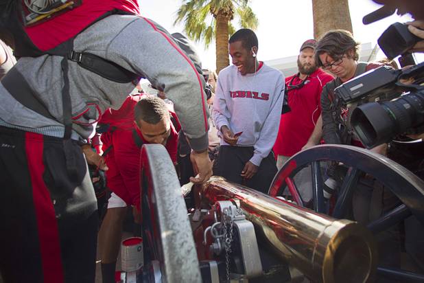 UNLV football players, including quarterback Caleb Herring, center, paint the Fremont cannon during a ceremony on UNLV campus Monday, Oct. 28, 2013. The UNLV football team beat Reno Saturday 27-22 to break an eight-year losing streak in the rivalry game and gain possession of the Fremont cannon.