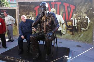 Former UNLV head basketball coach Jerry Tarkanian sits next to an oversized statue of himself after it was unveiled in front of the Thomas & Mack Center Wednesday, Oct. 30, 2013.
