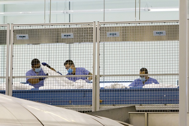 A production line of employees work diligently sorting and searching for secretly hidden ink packets by an anonymous perpetrator during a walk-through of Apex Linen in Las Vegas Tuesday, October 30, 2013.