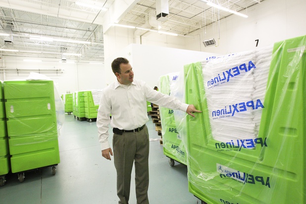 Executive Vice President Marty Martin talks about Apex's unique soft and bright white linens available to clients during a walk-through of Apex Linen in Las Vegas Tuesday, October 30, 2013.