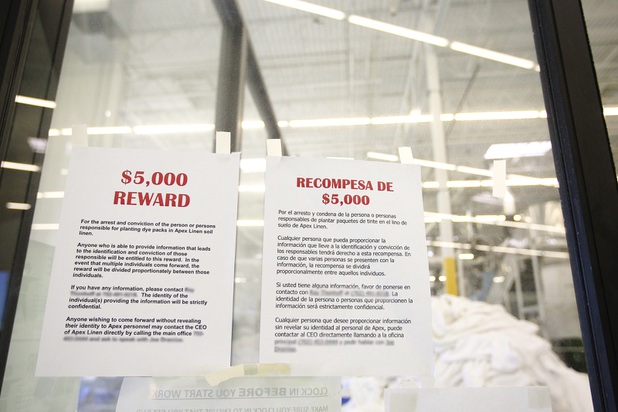 Hoping to discover the anonymous perpetrator who is sewing in ink packets into linens, $5,000 reward posters are posted in the work areas at Apex Linen in Las Vegas Tuesday, October 30, 2013.  (Contact names and telephone numbers have been blurred for confidentiality purposes.)