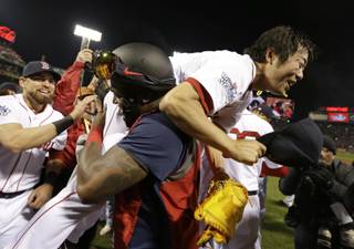 Boston Red Sox's David Ortiz lifts relief pitcher Koji Uehara after Boston defeated the St. Louis Cardinals in Game 6 of baseball's World Series Wednesday, Oct. 30, 2013, in Boston. The Red Sox won 6-1 to win the series.