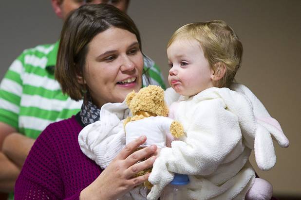 Bethany Overland holds Sydney, 2, during a Halloween adoption day at Family Court Thursday, Oct. 31, 2013. Sydney was dressed as a bunny and Judge Cynthia Giuliani dressed as a fairy godmother.