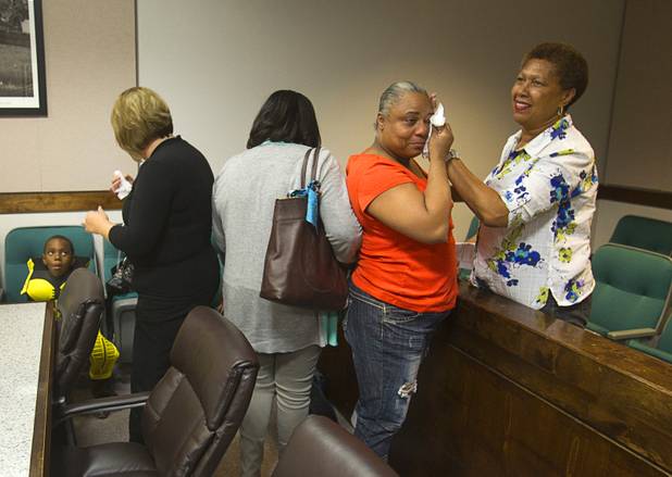 Wondene Jones wipes away tears of joy with her sister Linda Sellers after formerly adopting her grandchildren Elijah, left, 6, and Jessie, 4, (not pictured) during a Halloween adoption day at Family Court Thursday, Oct. 31, 2013.