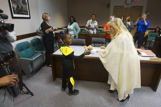Elijah Jones, 6, dressed as a ninja, is presented with a teddy bear by Judge Cynthia Giuliani, dressed as a fairy godmother, during a Halloween adoption day at Family Court Thursday, Oct. 31, 2013.