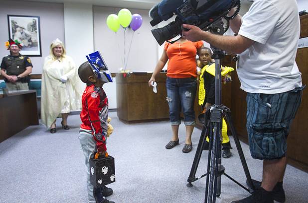Jessie Jones, 4, dressed as a transformer, poses for a television cameraman during a Halloween adoption day at Family Court Thursday, Oct. 31, 2013.