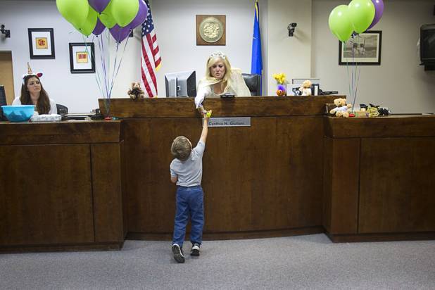 Eric James Templeton Jr., 3, received candy from Judge Cynthia Giuliani, dressed as a fairy godmother, during a Halloween adoption day at Family Court Thursday, Oct. 31, 2013.