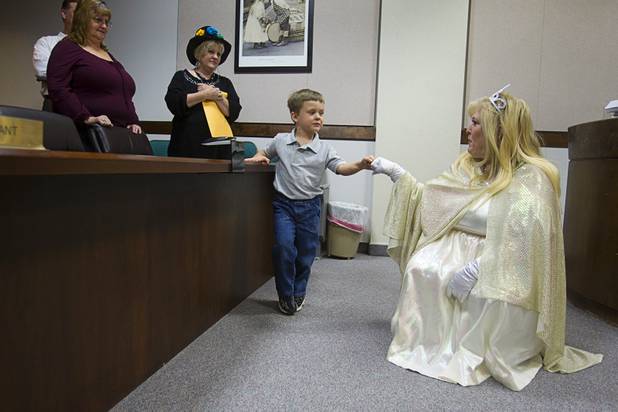 Eric James Templeton Jr., 3, gives a fist bump to Judge Cynthia Giuliani, dressed as a fairy godmother, during a Halloween adoption day at Family Court Thursday, Oct. 31, 2013.