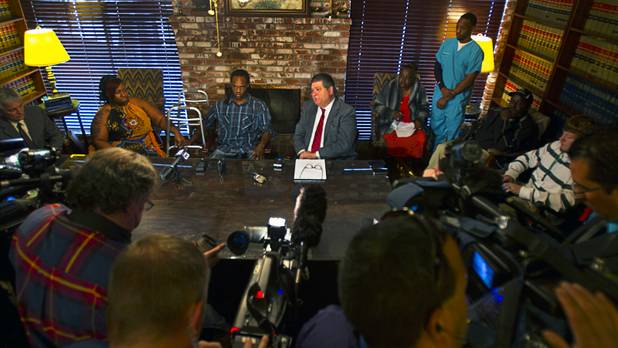 Antoine Hodges, center left, sits between his wife Annette and his lawyer Cal Potter during a news conference Friday, Nov. 1, 2013. Hodges was mistaken as homicide suspect and shot by a Metro Police officer Oct. 21, 2013.