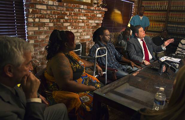 Antoine Hodges, center, sits between his wife Annette and his lawyer Cal Potter during a news conference Friday, Nov. 1, 2013. Hodges was mistaken as homicide suspect and shot by a Metro Police officer Oct. 21, 2013.