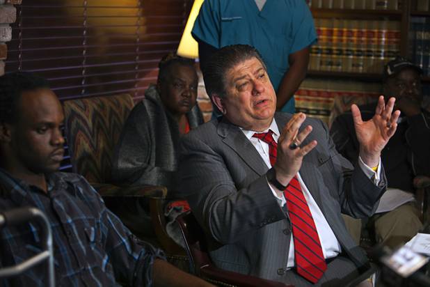 Attorney Cal Potter talks about his client Antoine Hodges, left, during a news conference Friday, Nov. 1, 2013. Hodges was mistaken as homicide suspect and shot by a Metro Police officer Oct. 21, 2013.