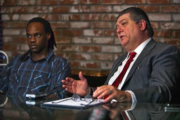 Attorney Cal Potter talks about his client Antoine Hodges, left, during a news conference Friday, Nov. 1, 2013. Hodges was mistaken as homicide suspect and shot by a Metro Police officer Oct. 21, 2013.