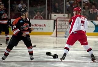 Las Vegas Wranglers forward Alexandre Mentink (7) drops his gloves and prepares to fight Fort Wayne Komets winger Kaleigh Schrock (79) moments after the start of the first period on Saturday night.