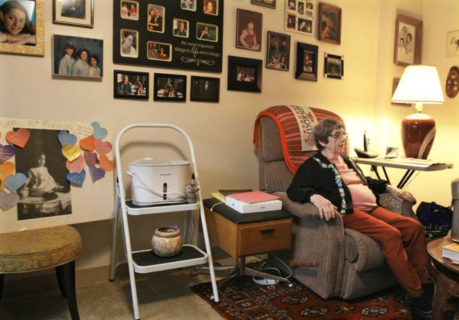 In this Sept. 18, 2013 photo, Holocaust survivor Margie Oppenheimer, 89, sits in her apartment surrounded by family photos at the retirement community called Selfhelp Home, on the North Side of Chicago. Seventy-five years ago, she awoke with a Nazi pointing a rifle in her 14-year-old face. It was Nov. 9, 1938, Kristallnacht _ the night of broken glass _ when the Nazis coordinated a wave of attacks in Germany and Austria, smashing windows, burning synagogues, ransacking homes, looting Jewish-owned stores. They trashed the familys apartment and small department store in Oelde, Germany. (AP Photo/Martha Irvine)