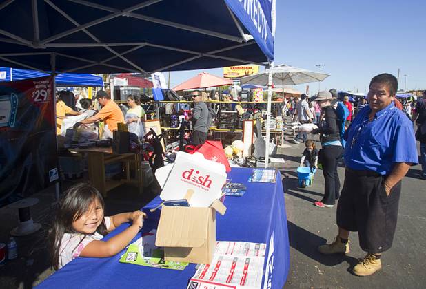 Juan Ruiz, right, and his daughter Joselyn, 5, man a DirecTV booth at the Broadacres Marketplace & Events Center Sunday Nov. 3, 2013.