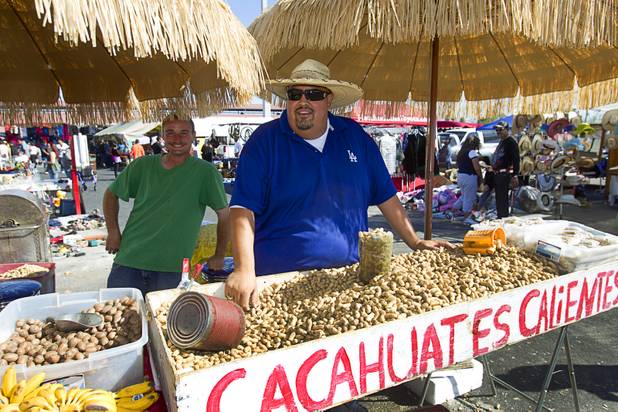 Charles Lockerbie, left, and Hector Escobedo wait for customers at the Broadacres Marketplace & Events Center Sunday Nov. 3, 2013. Peanuts make up a majority of his sales, said Escobedo.